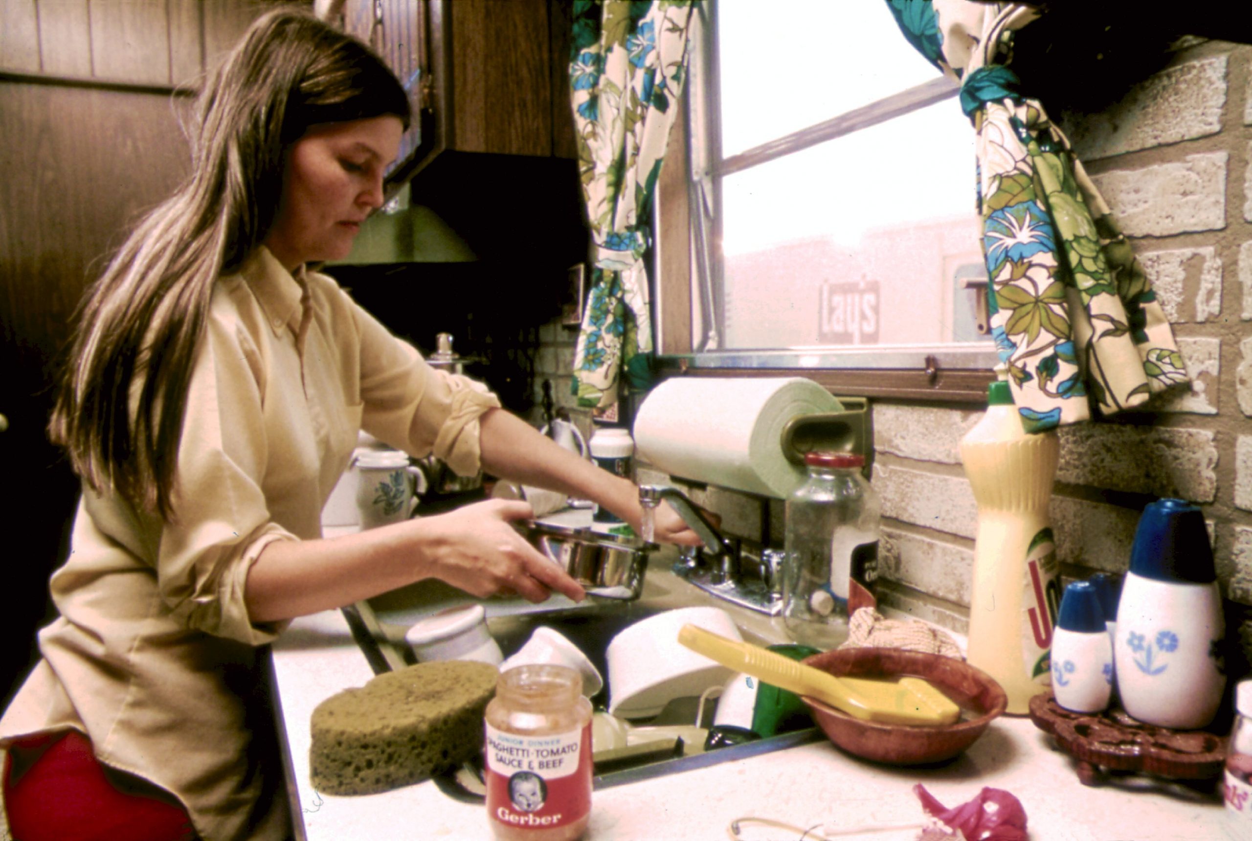 HOUSEWIFE IN THE KITCHEN OF HER MOBILE HOME IN ONE OF THE TRAILER PARKS. THE TWO PARKS WERE CREATED IN RESPONSE TO... NARA 558298 scaled